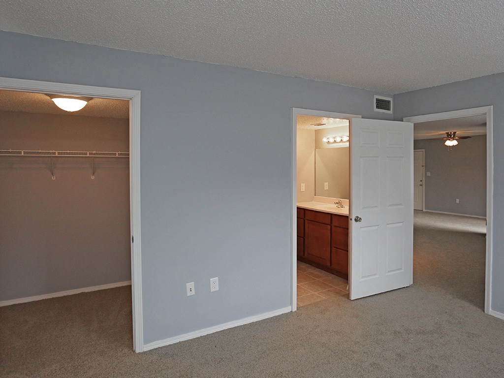 an empty bedroom with a closet and a bathroom