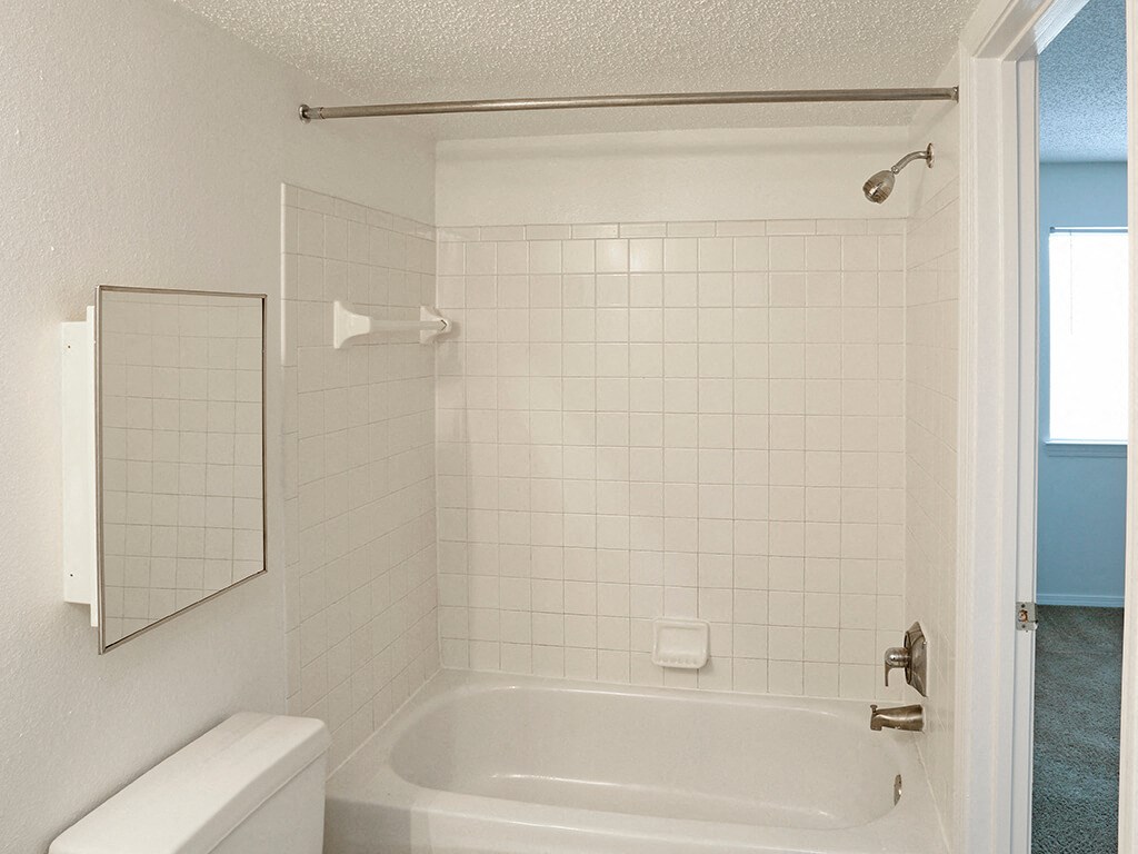 a white bathroom with a tub and a sink