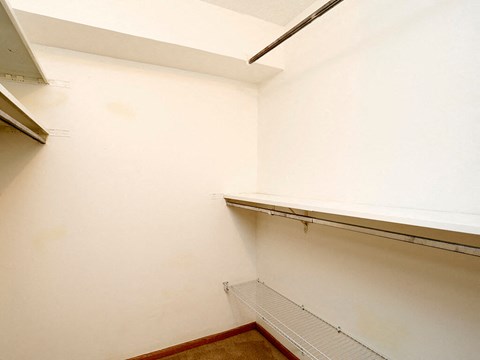 a white room with a shelf on the wall