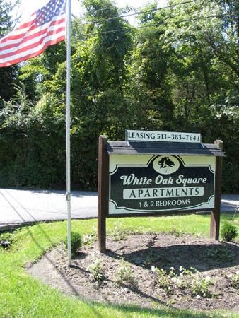 a sign for white oak square apartments with an flag