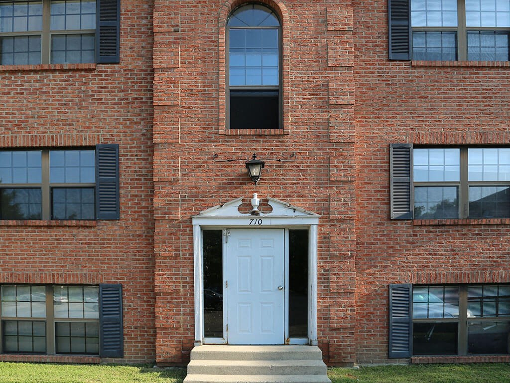 the front of a brick building with a white door
