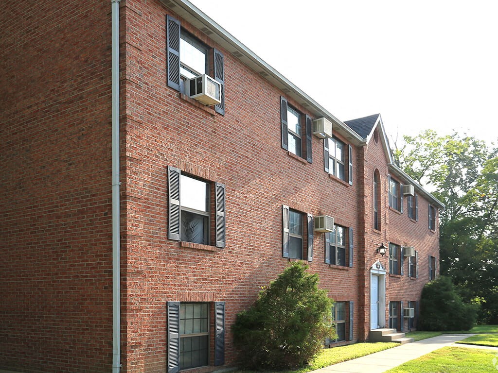 a red brick building with windows and a sidewalk