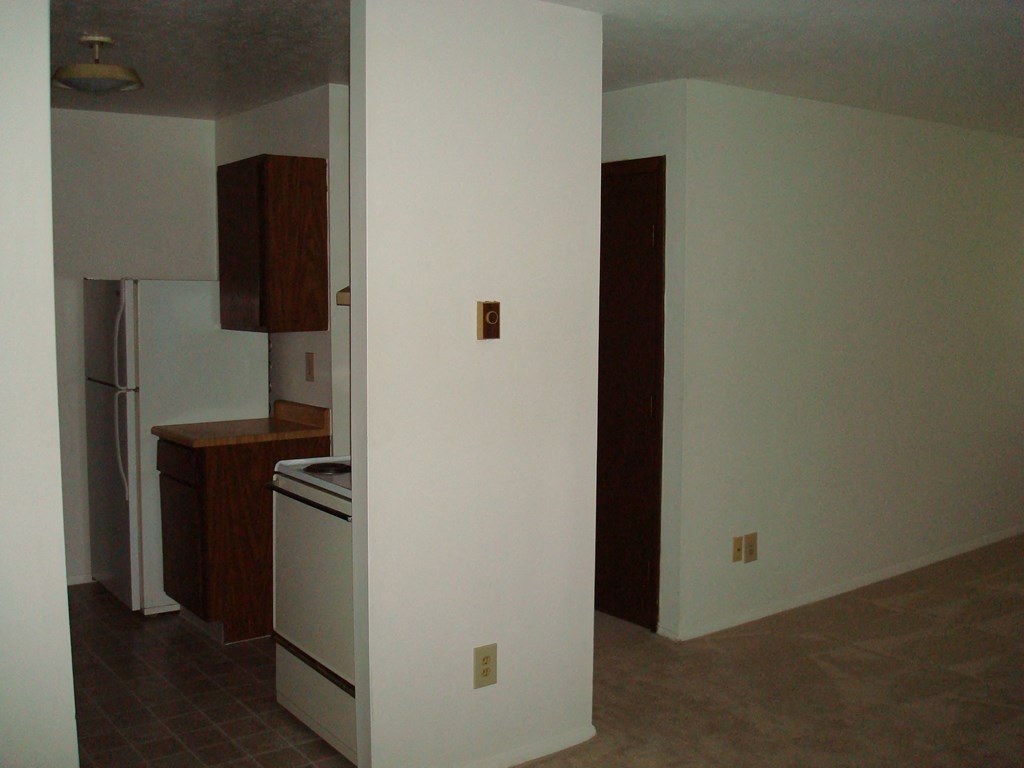 an empty kitchen with a stove and a refrigerator