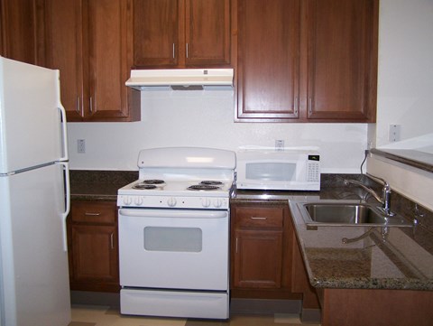 A white stove and oven in a kitchen with brown cabinets.