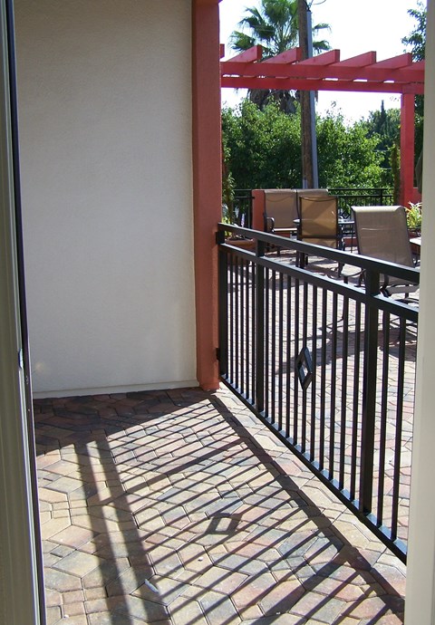 A black metal fence with a red pergola in the background.