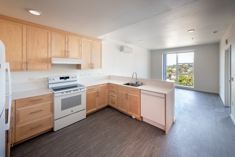 A kitchen with wooden cabinets and a white stove top oven.