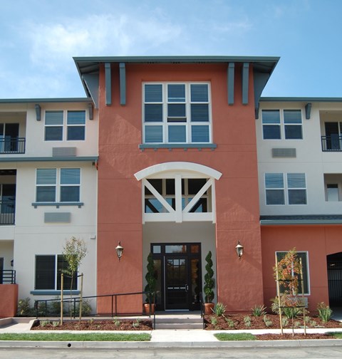 A building with a red and white facade has a black door and windows.