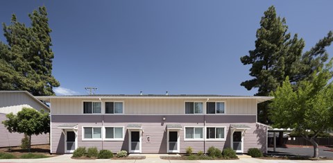 A two-story building with a flat roof and a garage door.
