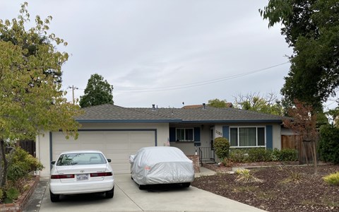 A house with a car parked in front of it.