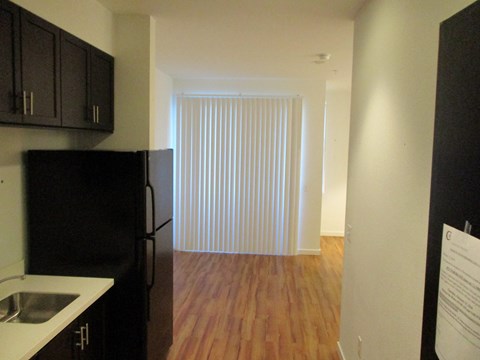 A kitchen with black cabinets and a black refrigerator.