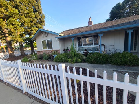 A white picket fence in front of a house.