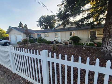 A white picket fence in front of a house.