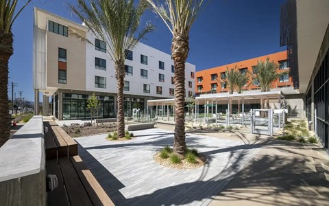 A modern building with a courtyard and palm trees.