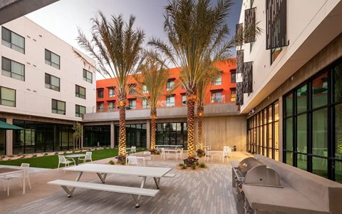 A modern building with a courtyard and palm trees.