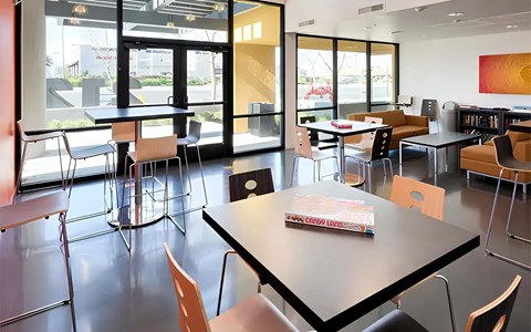 A room with tables and chairs and a book on one of the tables.