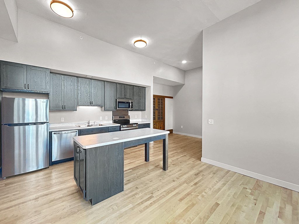 an open kitchen with stainless steel appliances and a counter top