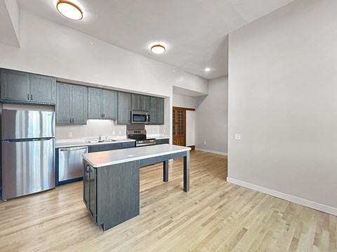 an open kitchen with stainless steel appliances and a counter top