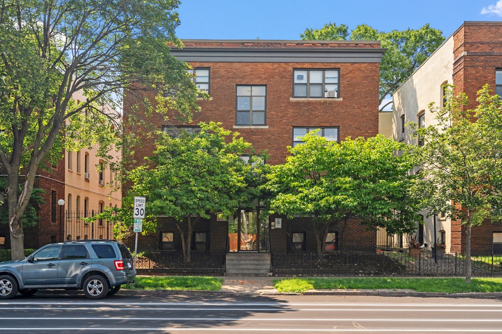 a red brick building with a blue suv parked in front