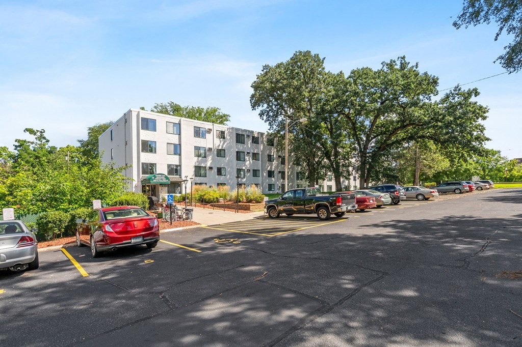a parking lot with cars in front of an apartment building