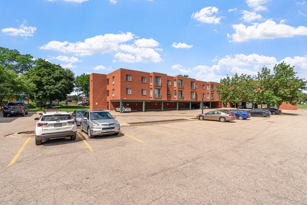 a parking lot with cars in front of a brick building
