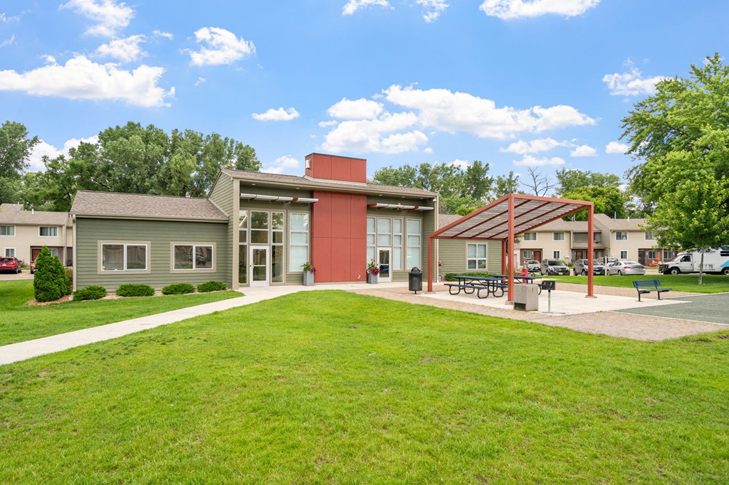 a building with a green lawn and a red pillar