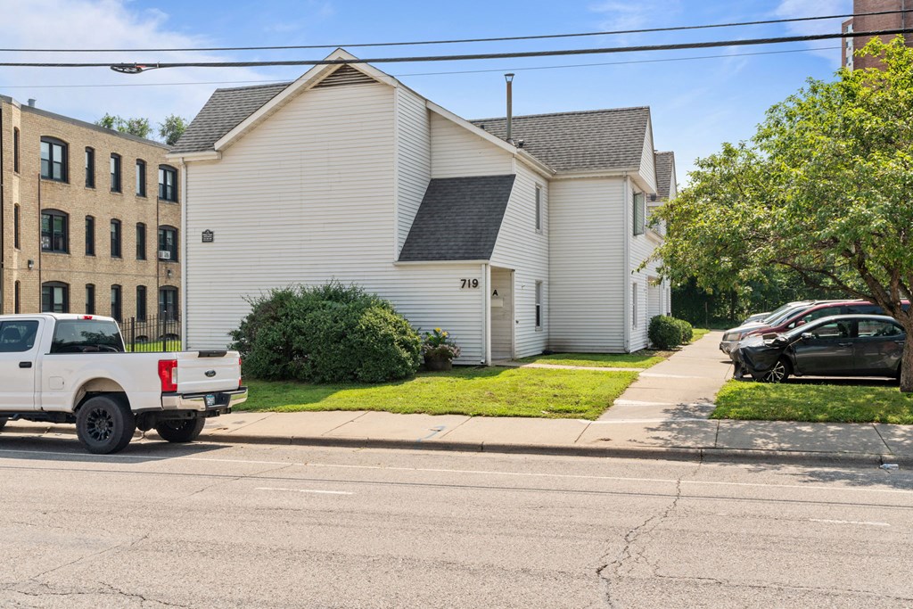 a white house on the corner of a street with a truck