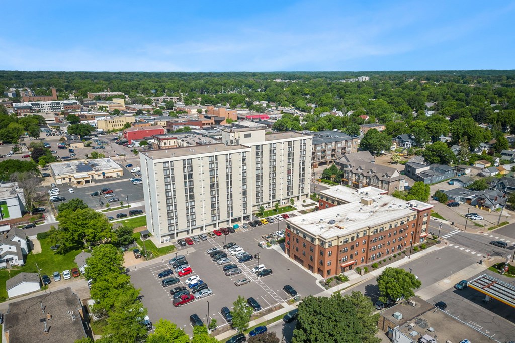 an aerial view of a city with a large building and a parking lot