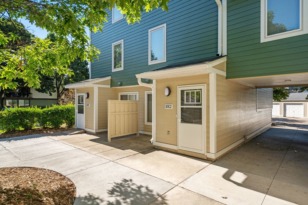 the front of a blue house with a sidewalk and a driveway