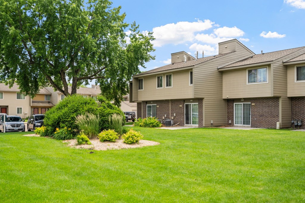 the view of an apartment building with a yard and grass