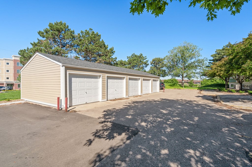 a parking lot with a row of garages on the side of a building