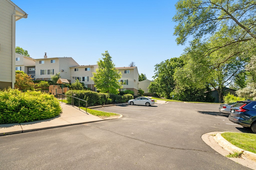 the view of an apartment complex with a car parked on the street