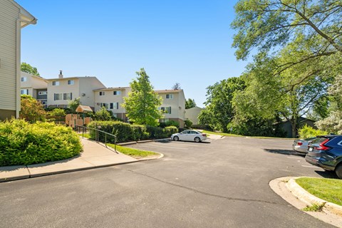 the view of an apartment complex with a car parked on the street