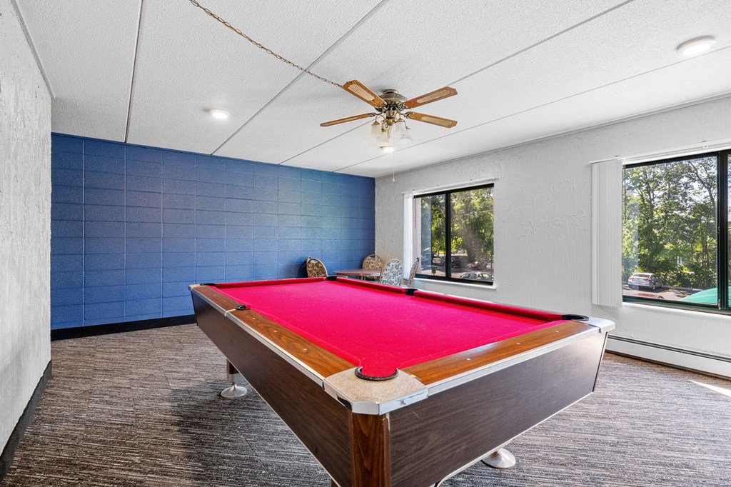 a pool table in a house with a ceiling fan