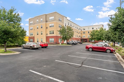 a parking lot with cars in front of an apartment building