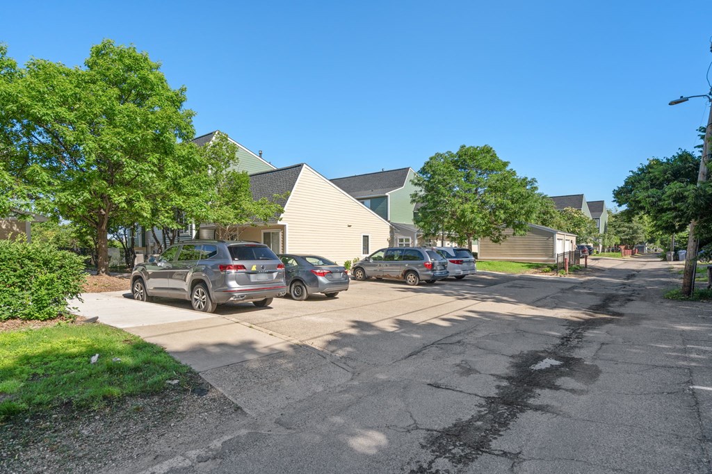 a parking lot with cars parked in front of houses