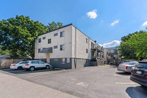 a large white building with cars parked in a parking lot