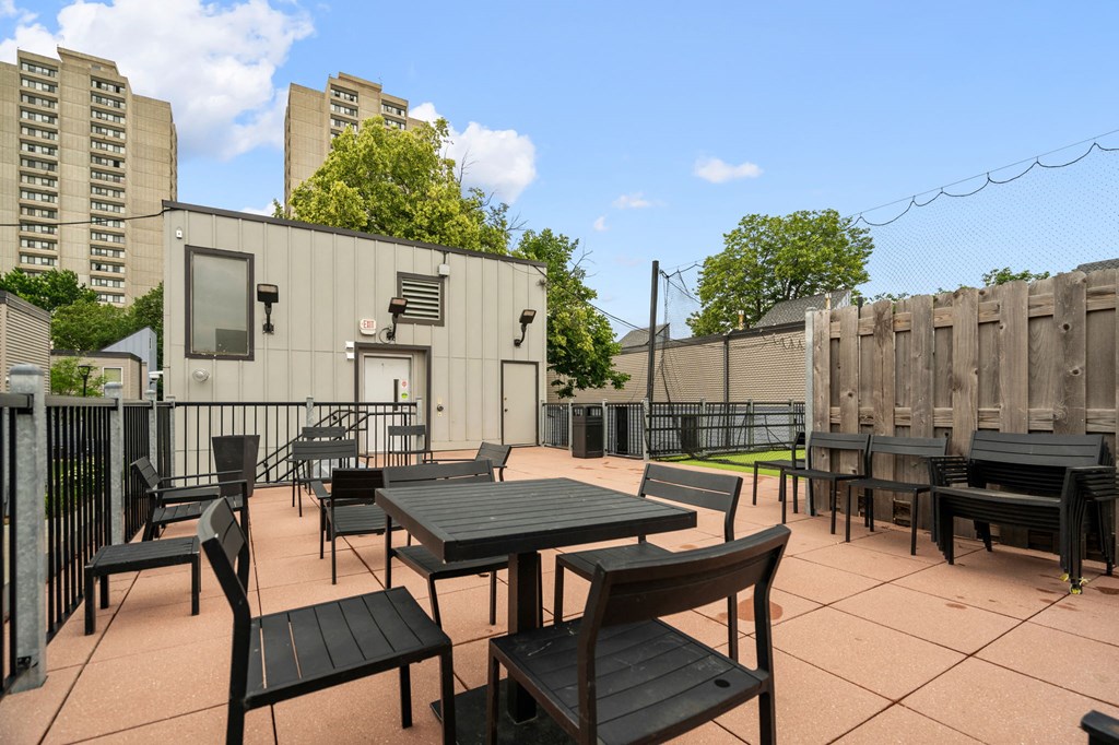 the patio of the building has tables and chairs and a fence