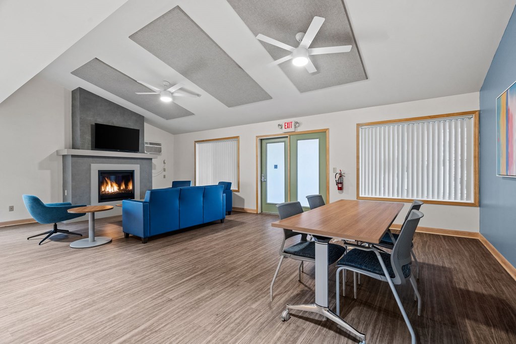a living room with a fireplace and a table and chairs