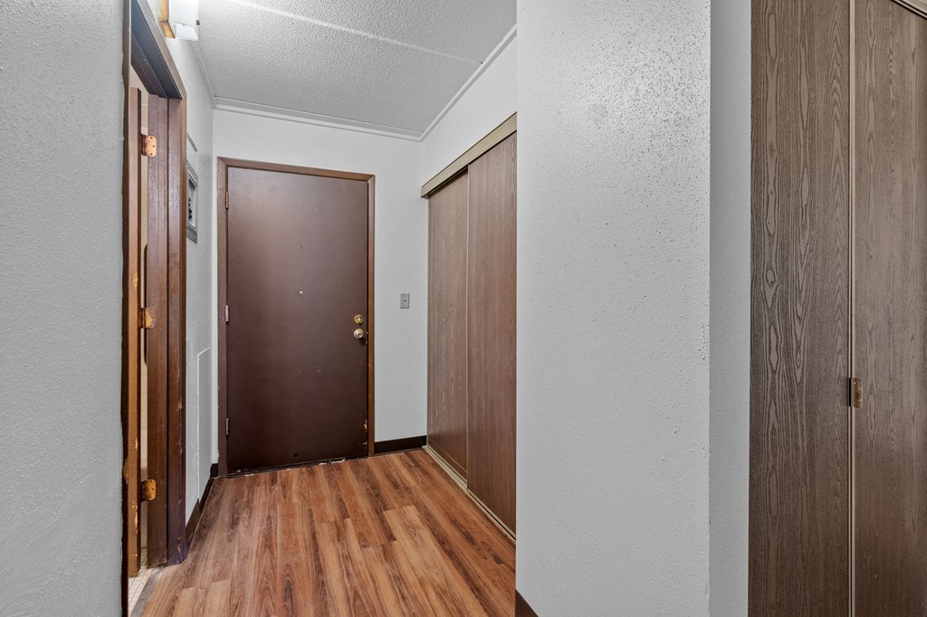 the entrance to a room with wooden floors and a door