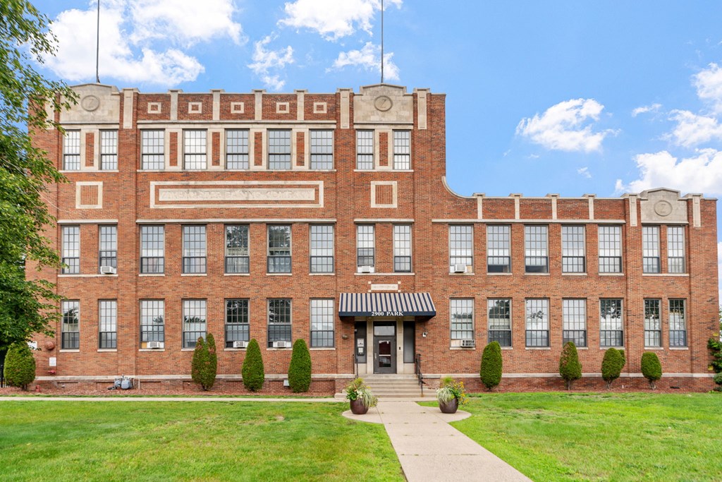 a large brick building with a sidewalk in front of it