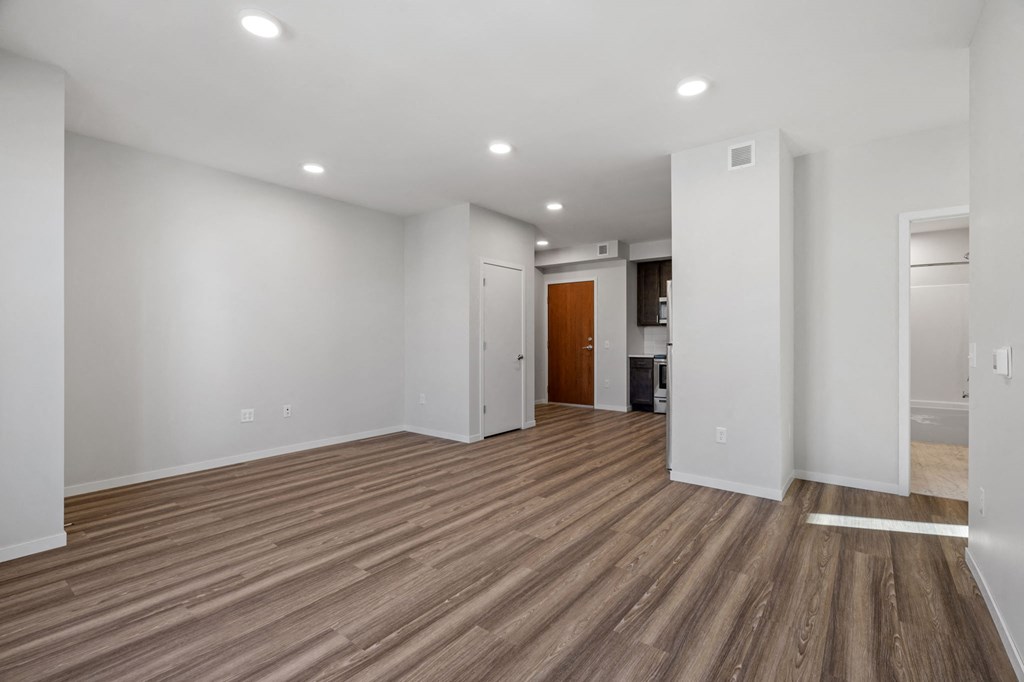 a living room with white walls and wood floors