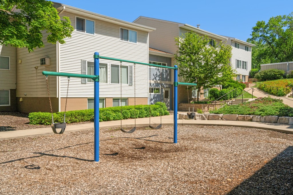 a swing set in front of an apartment building