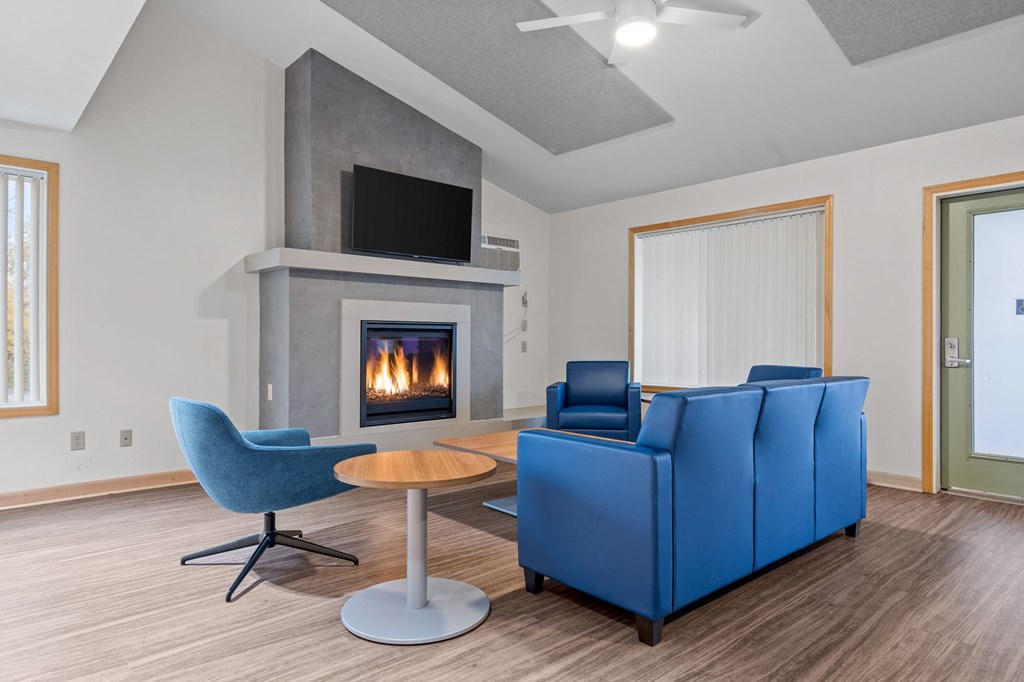 a living room with two blue couches and a fireplace