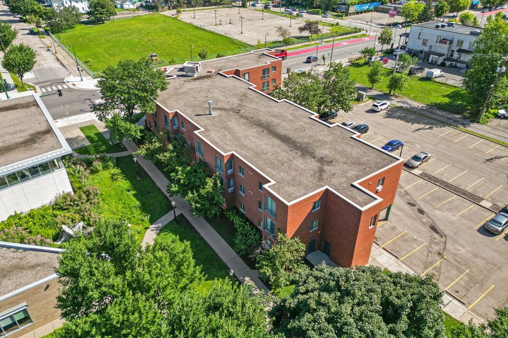 an aerial view of a brick building with a large roof