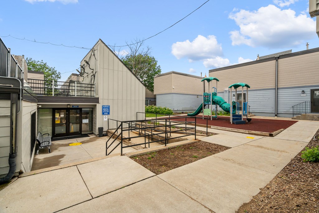 the childrens play area with playground equipment at the whispering winds apartments