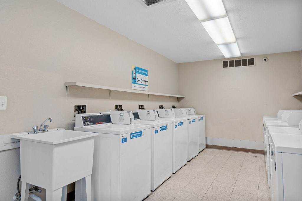 a row of washers and dryers in a laundry room