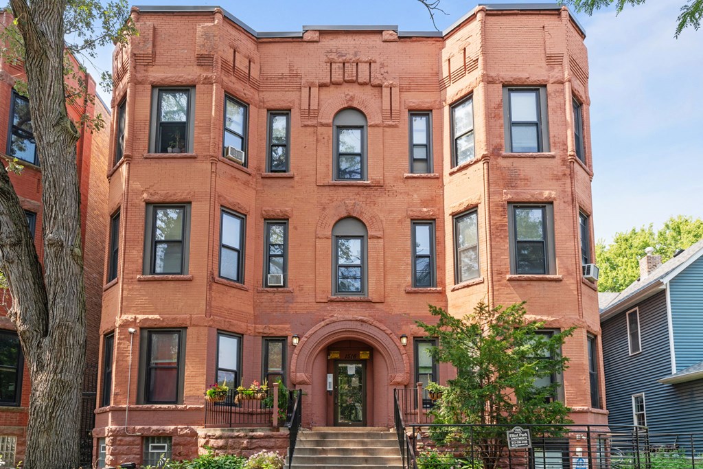 the exterior of a brick building with a front door and stairs