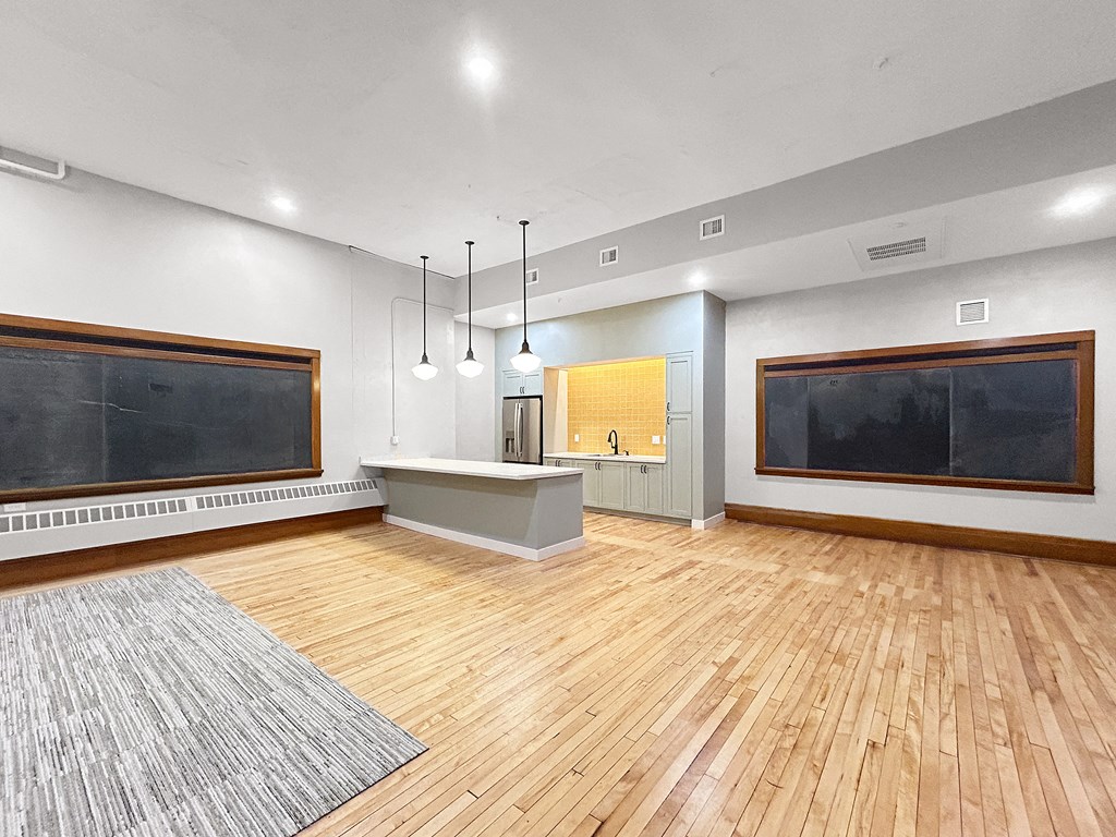 the living room has a wood floor and a large screen tv