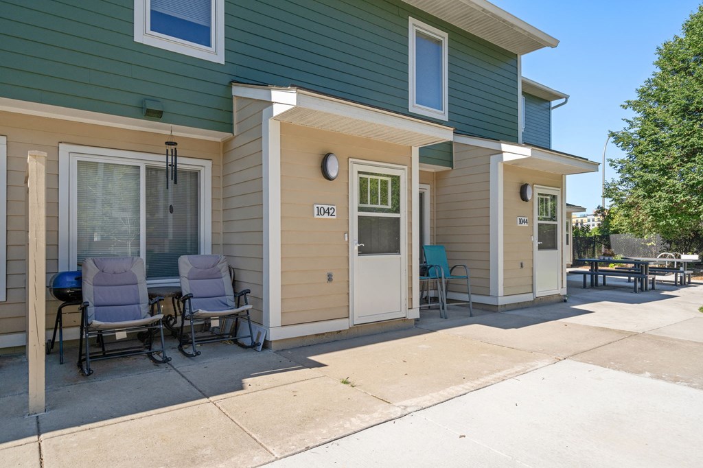the front porch of a house with a patio and chairs