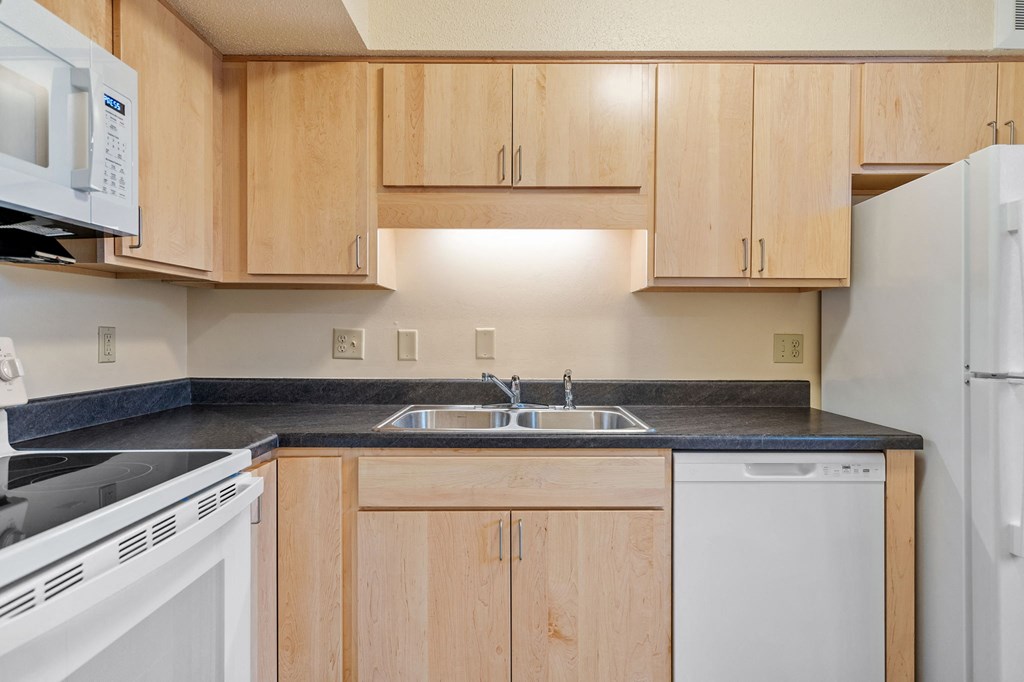 A kitchen with wooden cabinets and white appliances.